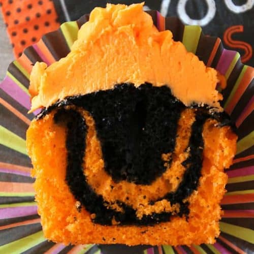 Easy Tie Dye Halloween Cupcakes with orange and black swirls topped with creamy orange buttercream for the most spooktacular treats!
