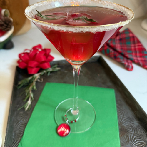 A festive Christmas Cranberry Martini with sugared rims, and fruit-filled rosemary ice cubes.
