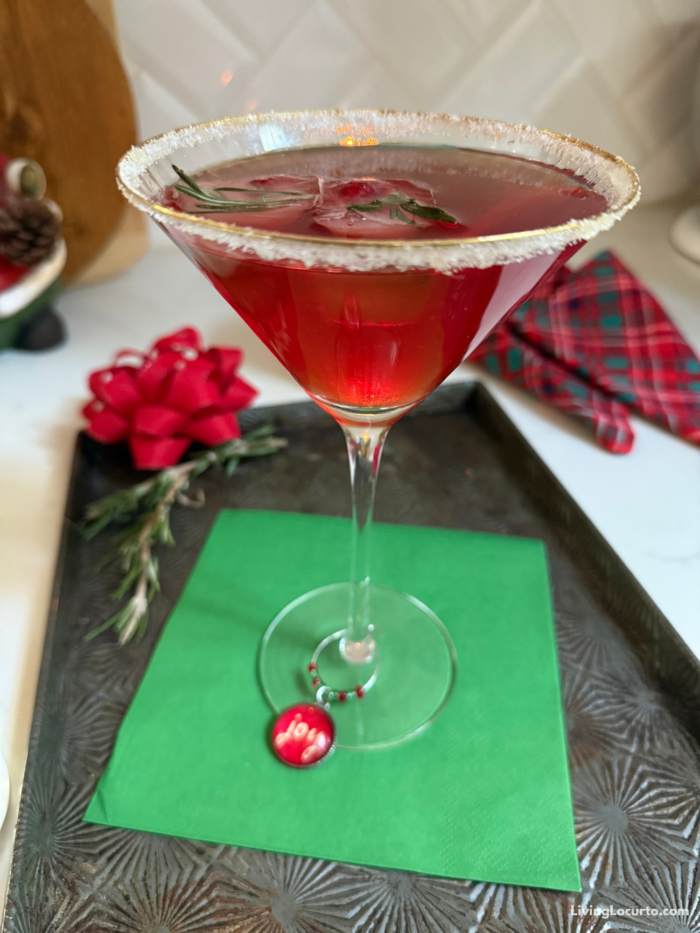 A festive Christmas Cranberry Martini with sugared rims, and fruit-filled rosemary ice cubes.