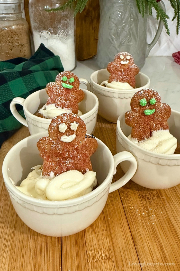 Gingerbread cupcakes in a coffee mug with gingerbread man cookies on top.