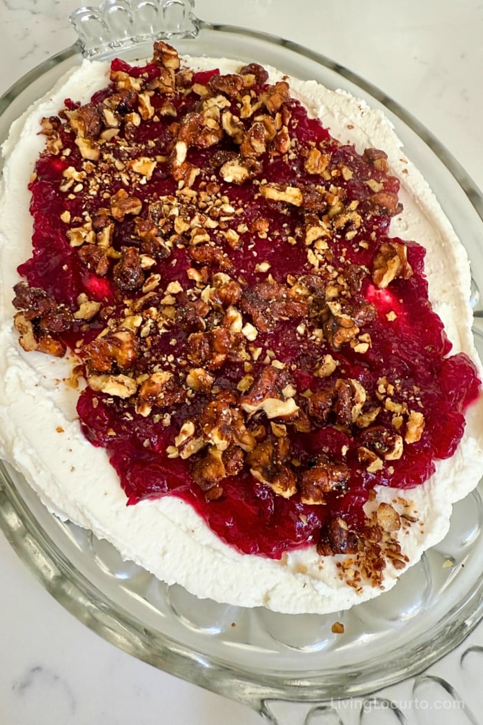 Hot Honey Whipped Goat Cheese Dip with Cranberry & Walnuts on a glass platter served at a holiday party.