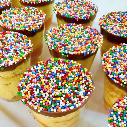 Mini Dot Cakes (Dot Shots) 9 Close up Mini Dot Cake shots with rainbow sprinkles and gold spoons on a white party platter.