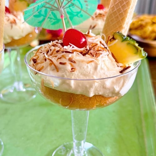 No-Bake Pina Colada Dip Cakes Recipe. Whipped dessert in a wine glass with drink umbrella