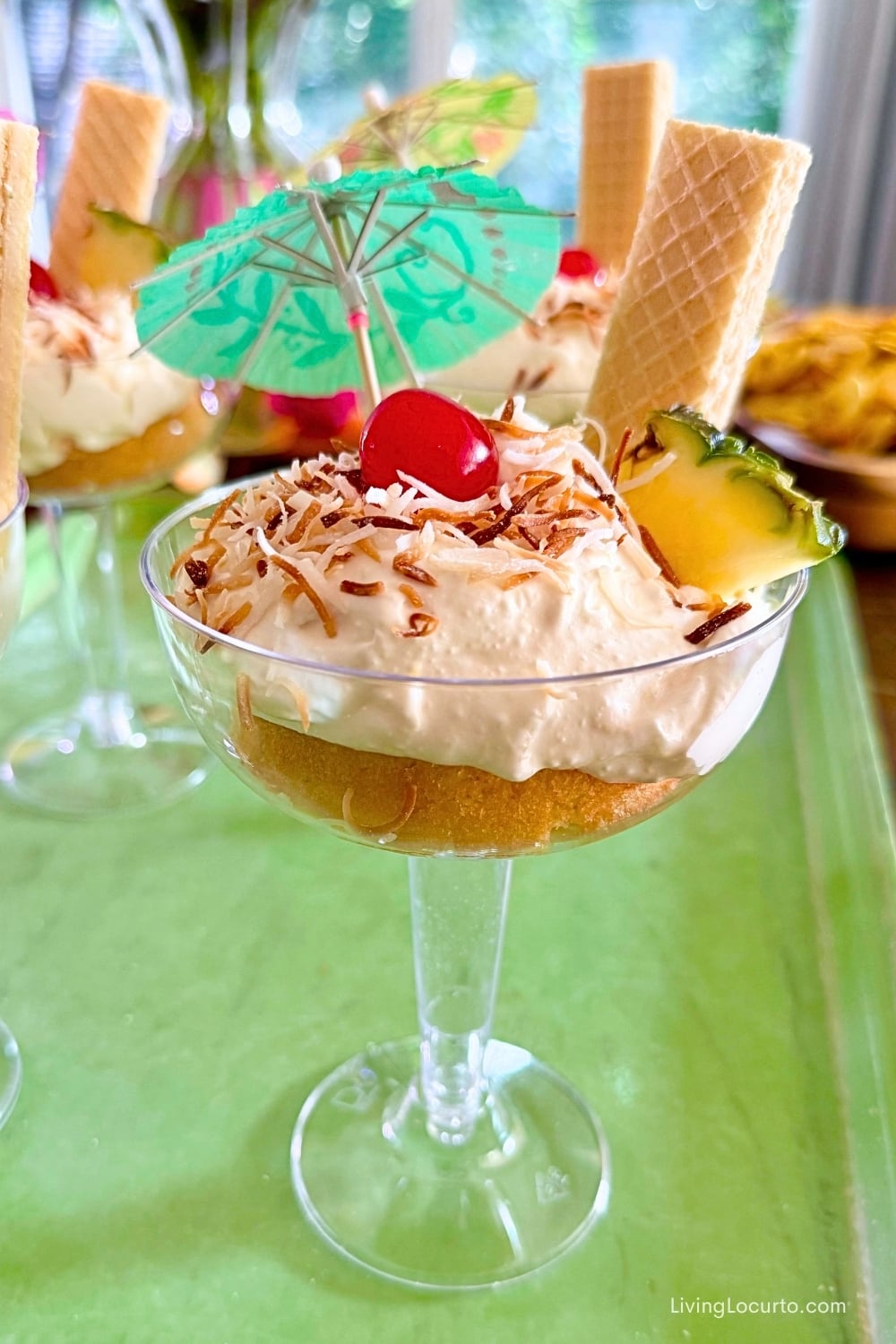 No-Bake Pina Colada Dip Cakes Recipe. Whipped dessert in a wine glass with drink umbrella