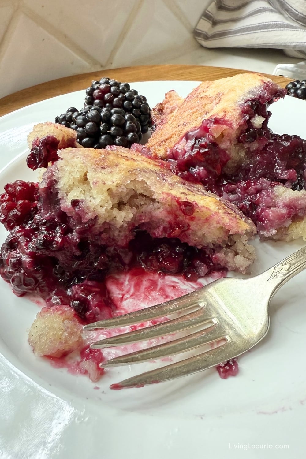 Spiced Blackberry Cobbler on a white plate with a fork.