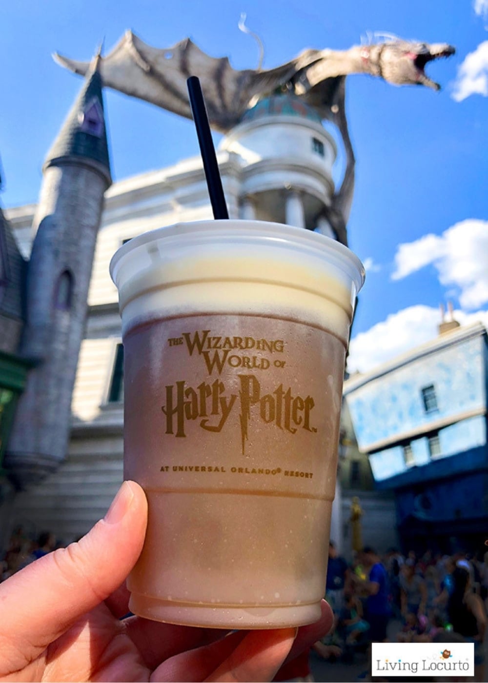 Hand holding a cup of butterbeer from Universal Orlando in the harry potter World